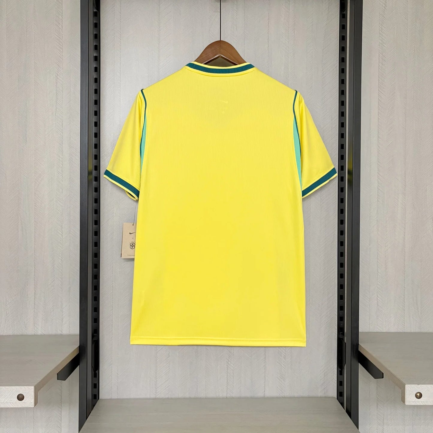 Yellow sports jersey with green accents on a hanger in a locker room.