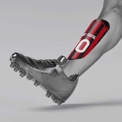 Gray soccer cleat with a red and black shin guard on a gray background