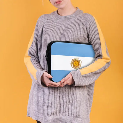 Person holding a pouch with the design of the Argentine flag against a yellow background