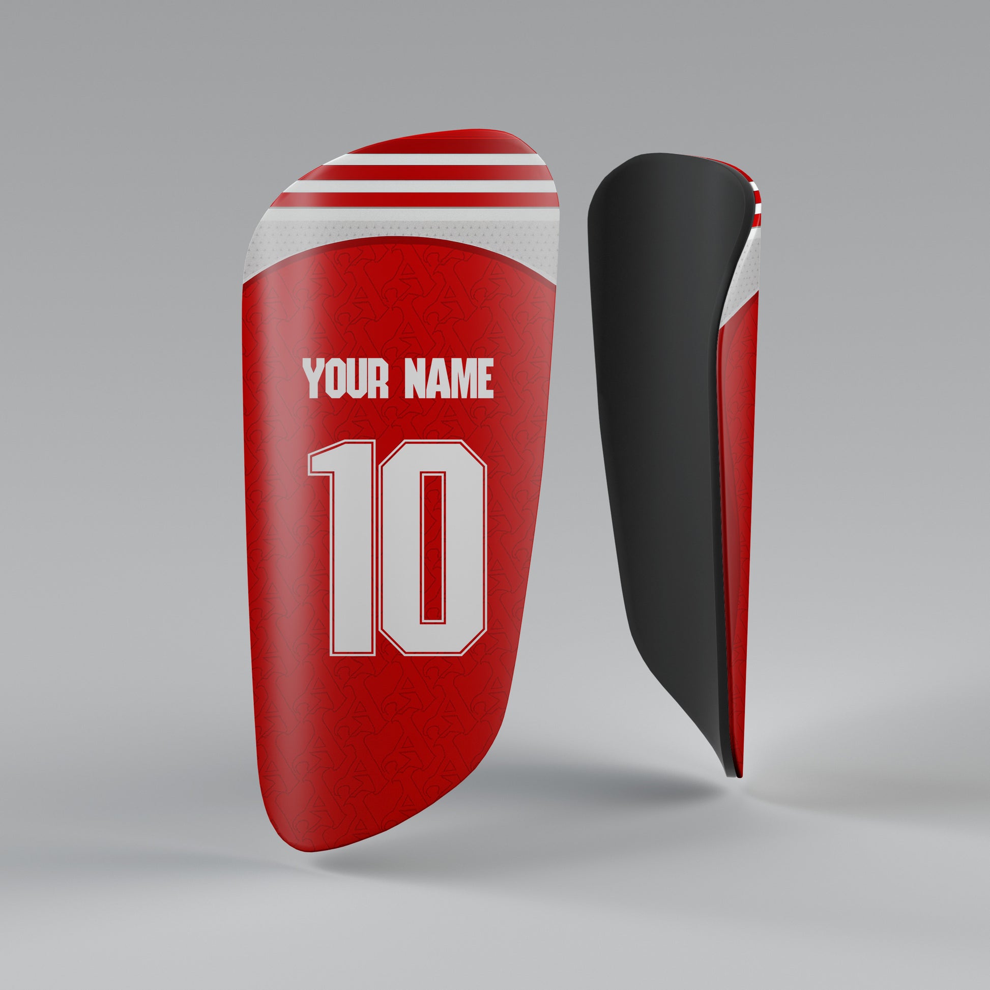 Red and black shin guards with customizable text on a gray background
