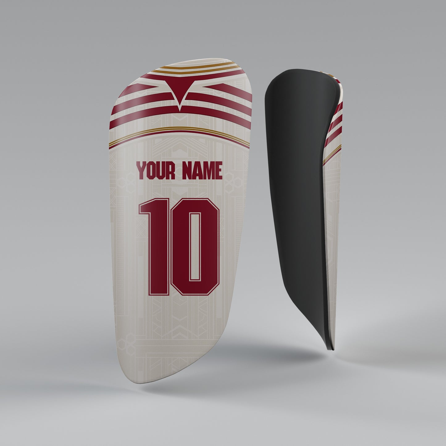 Customizable shin guard with space for name and number on a gray background