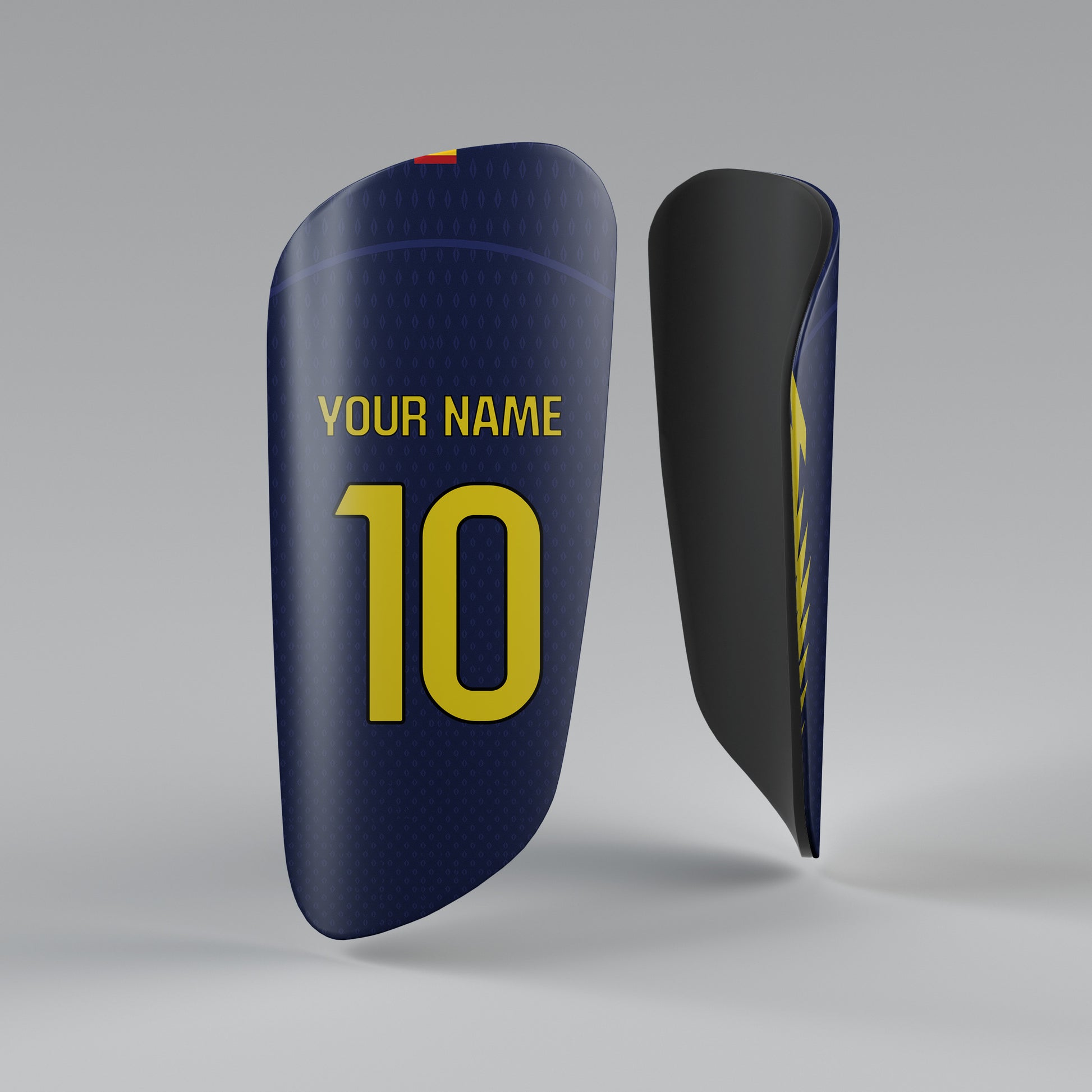 Navy blue shin guards with yellow text on a gray background