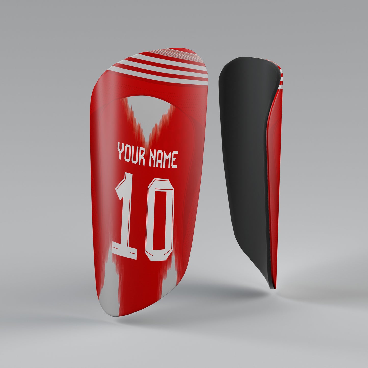 Red and black shin guards with customizable text on a gray background