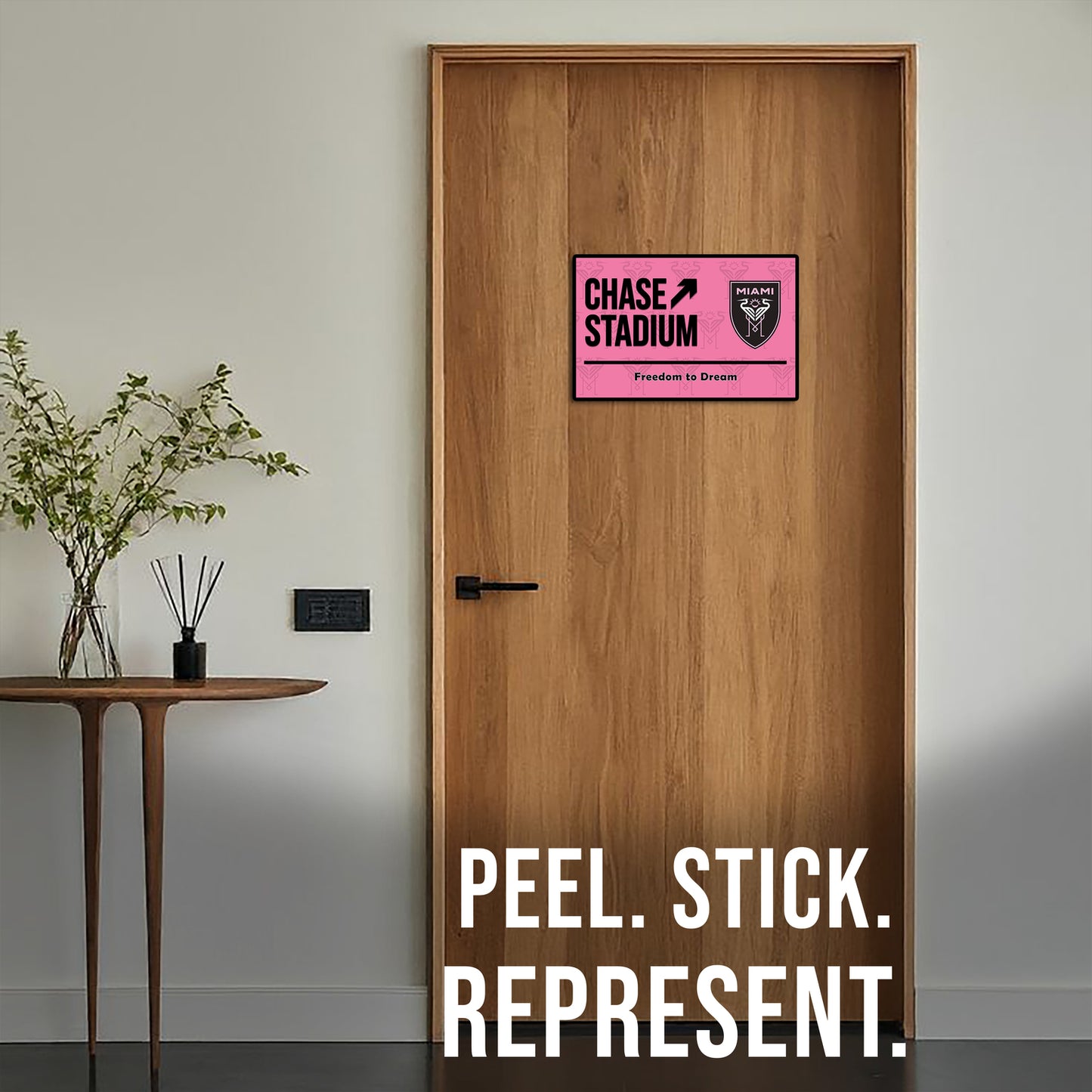 Wooden door with a pink and black sign labeled 'Chase Stadium' and text 'Peel. Stick. Represent.'.