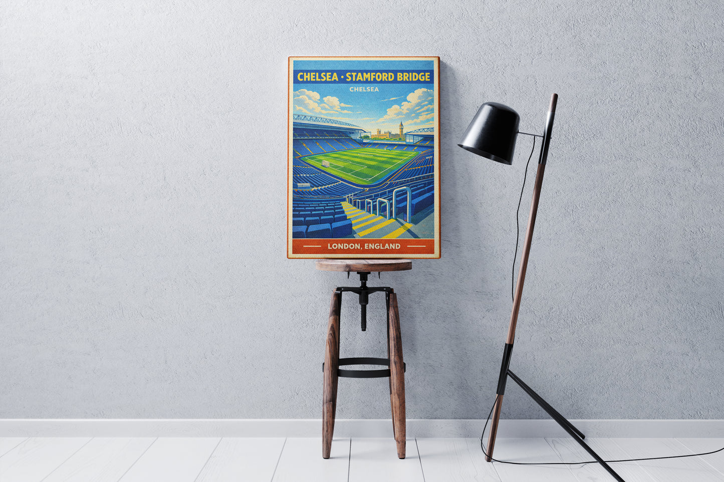 Vintage-style poster of Chelsea vs. Stamford Bridge on a stool against a gray wall.