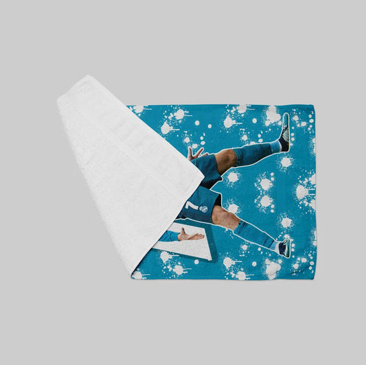 Blue fabric with white splashes and a person lying on it, with a white sheet partially covering it.