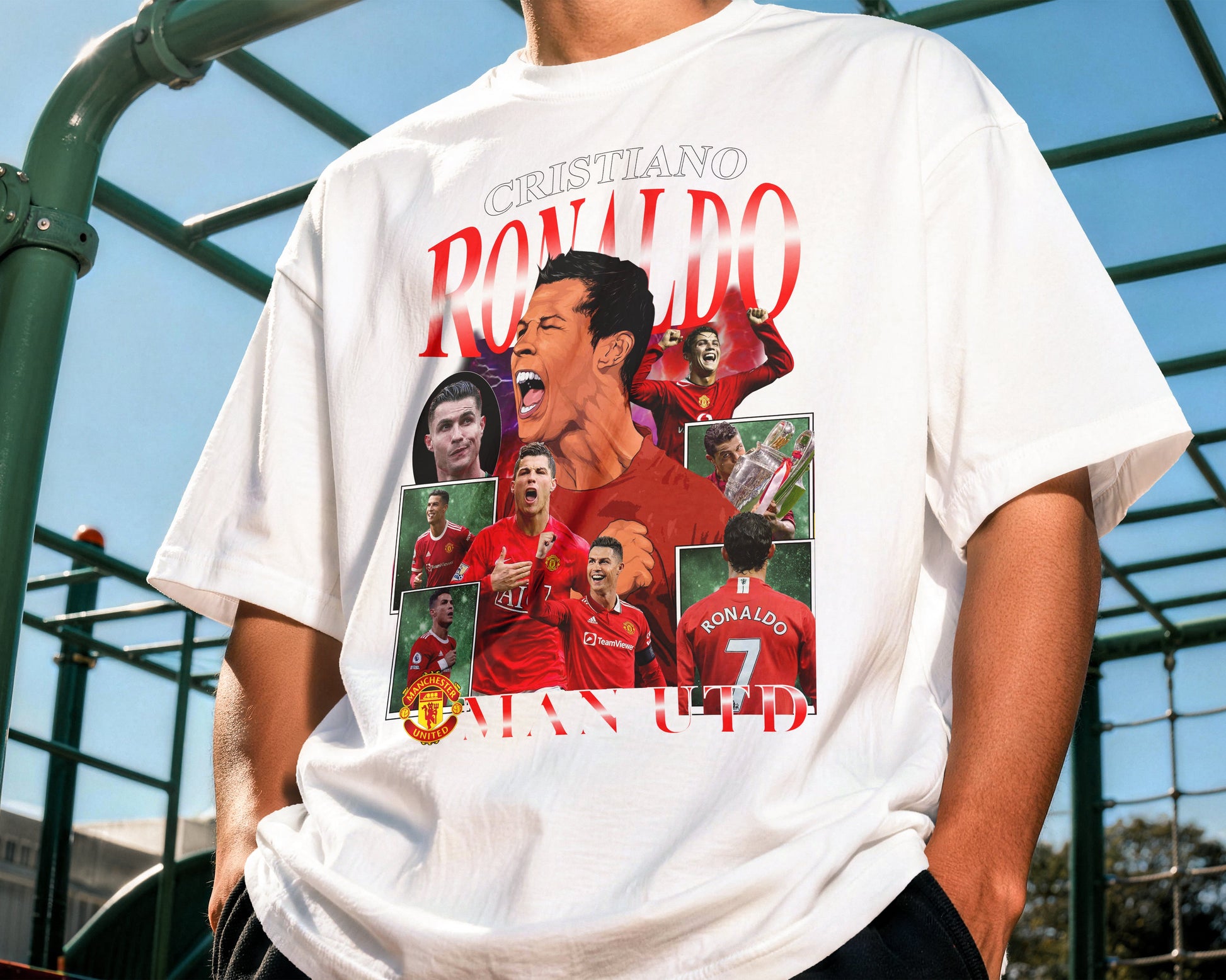 Person wearing a white t-shirt with a graphic design of a famous soccer player outdoors.