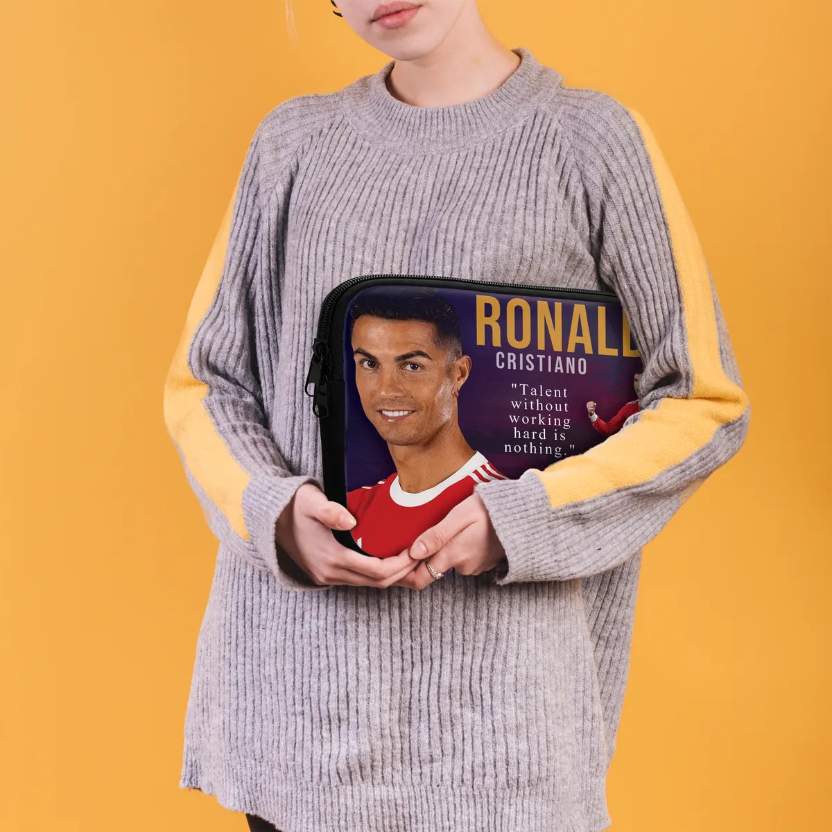 Person holding a pouch with a portrait and text of a famous person against a yellow background