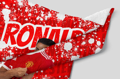 Person holding a red sports jersey with 'RONALDO' and a logo, against a red and white patterned background.