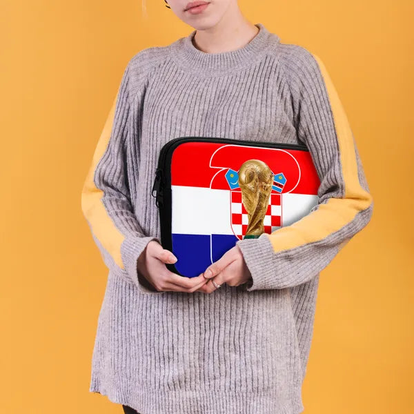 Person holding a pouch with a World Cup design against an orange background