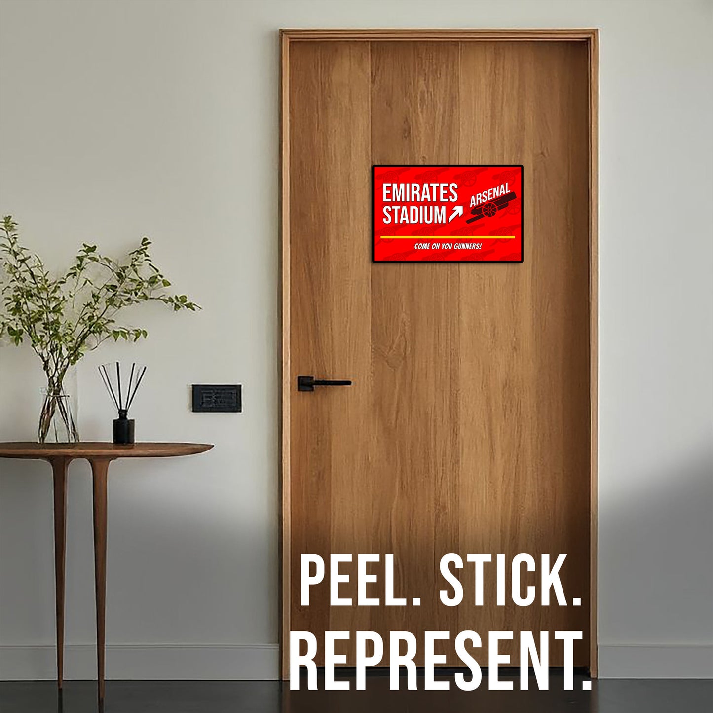 Wooden door with a red Emirates Stadium sign and 'Peel. Stick. Represent.' text.