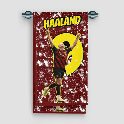 Towel with a soccer player in a red and yellow uniform on a red background with 'Haaland' text.