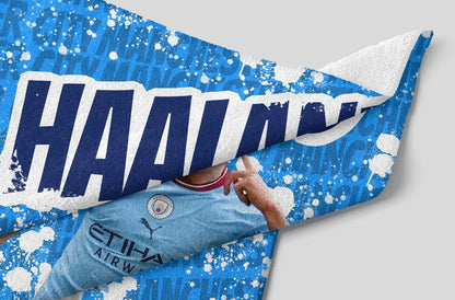 Blue and white sports towel with 'HAAHN' branding on a gray background