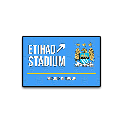 Etihad Stadium sign with Manchester City logo on a blue background
