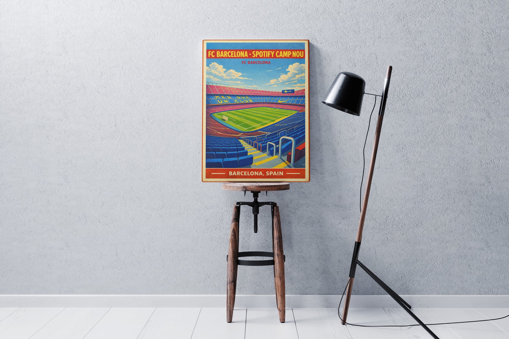 Colorful poster of a stadium on a stand against a gray wall with a lamp.