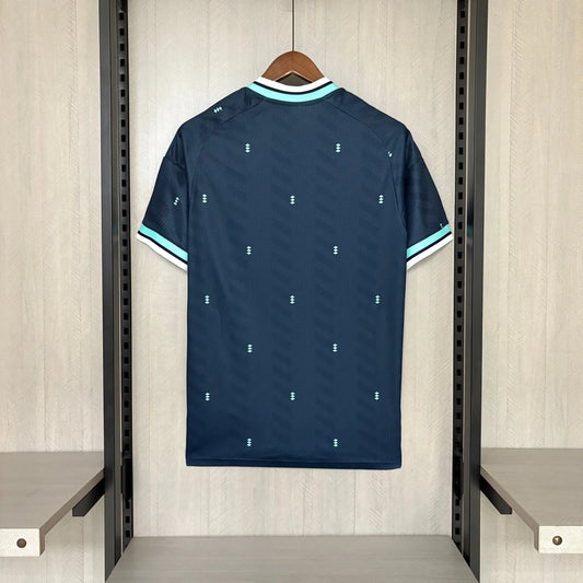 Navy blue sports jersey with white and light blue accents on a hanger against a wooden panel background.