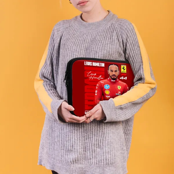 Person holding a laptop case with a Formula 1 driver design on a yellow background