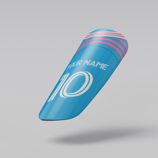 Blue shin guard with pink accents and customizable text on a gray background
