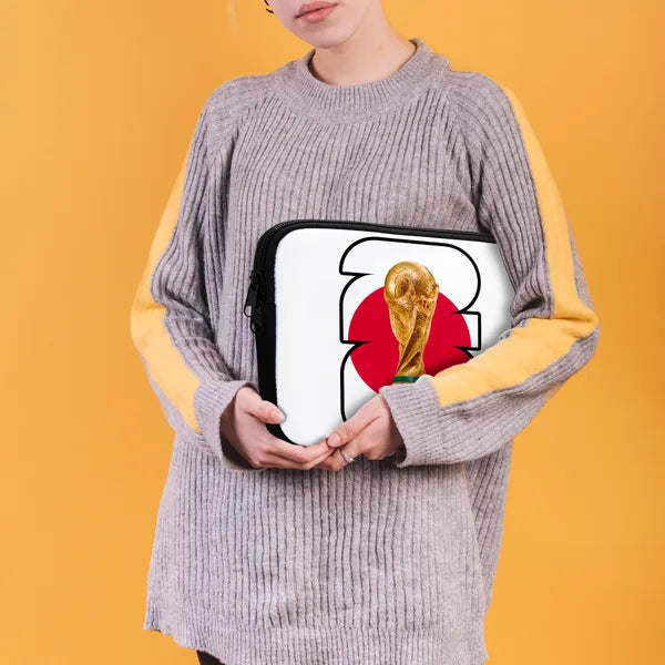 Person holding a laptop case with a World Cup trophy design on an orange background