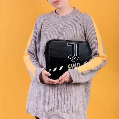 Person holding a black pouch with a logo against a yellow background