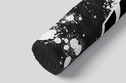 Roll of black fabric with white abstract patterns on a gray background