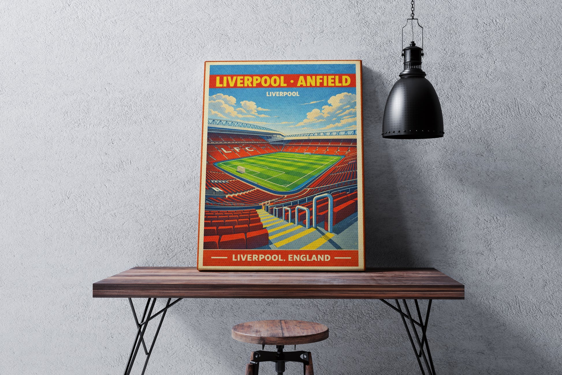 Framed poster of Liverpool Anfield on a wooden table against a gray wall.