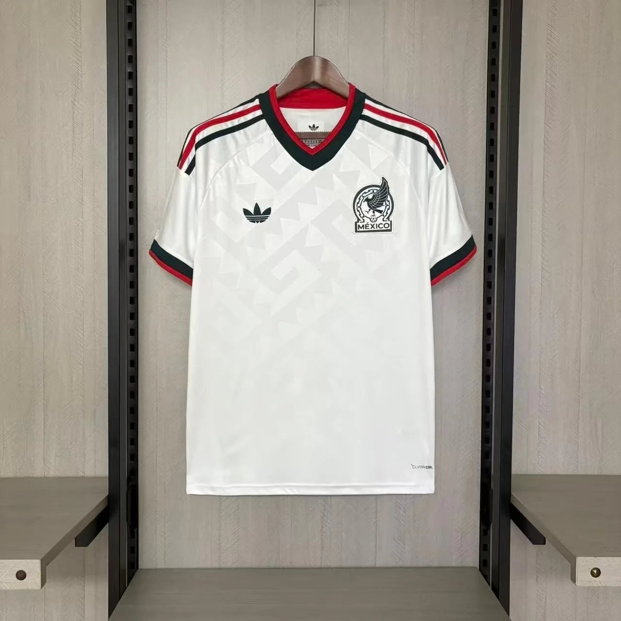 White sports jersey with red and black accents hanging on a rack.