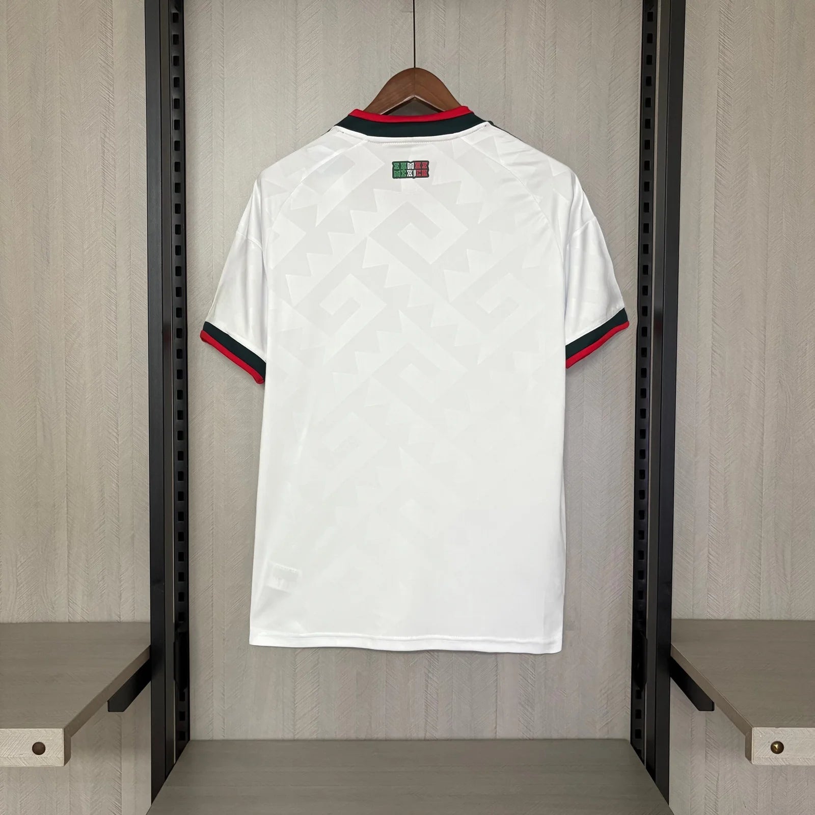White sports jersey with red and blue accents hanging in a locker room.