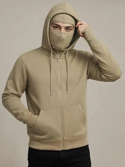 Person wearing a beige hoodie with a face mask on a plain background
