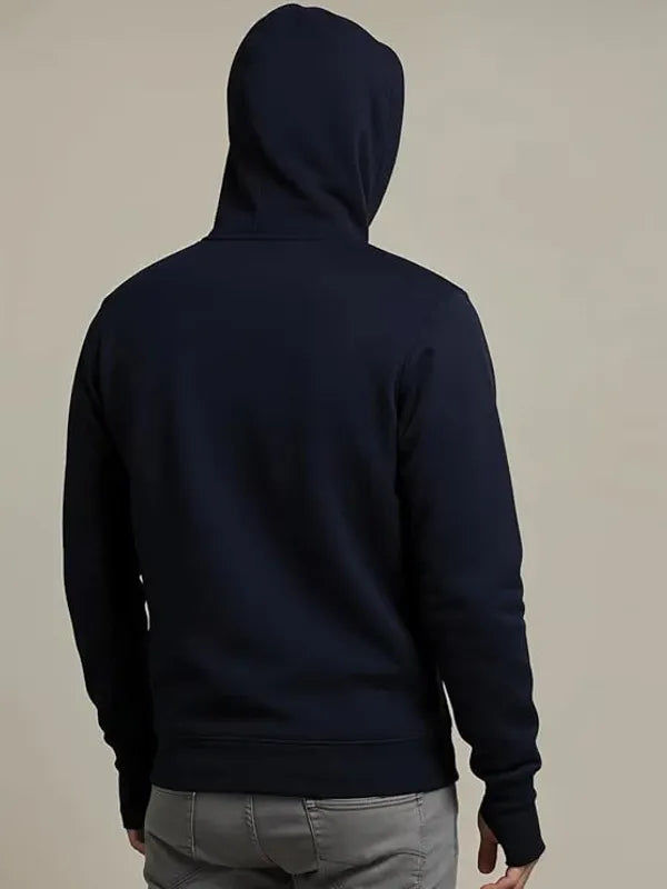 Person wearing a black hoodie with the back facing the camera on a beige background