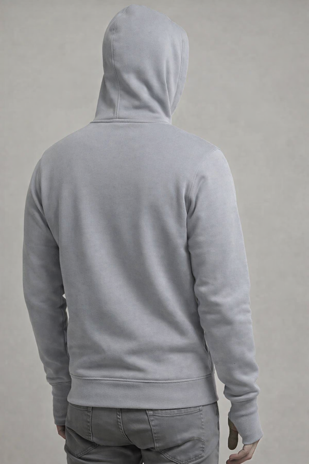 Person wearing a gray hoodie from behind on a plain background