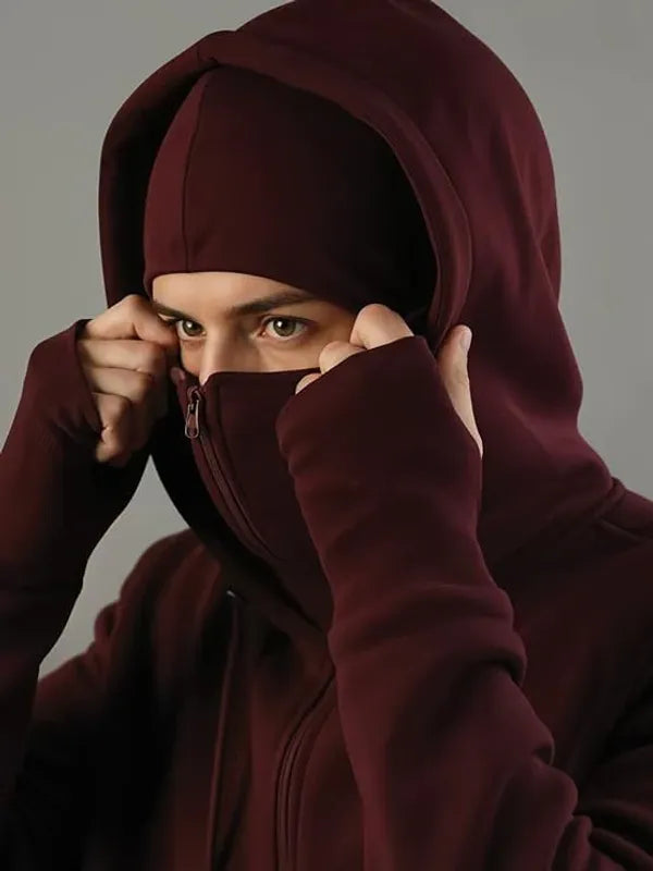 Person wearing a dark red hoodie with a zipper, covering their face.