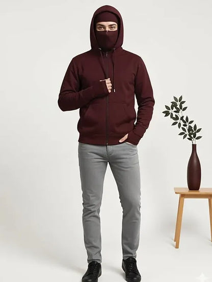 Person wearing a maroon hoodie and gray pants on a white background