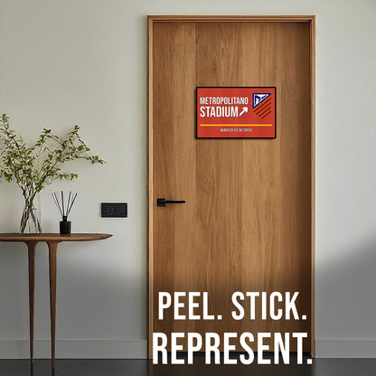 Wooden door with a Metropolitano Stadium sign and 'Peel. Stick. Represent.' text.
