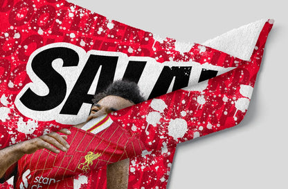 Person wearing a Liverpool FC jersey with a red and white patterned background