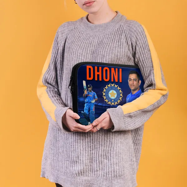 Person holding a pouch with images of a cricket player and text 'DHONI' on an orange background