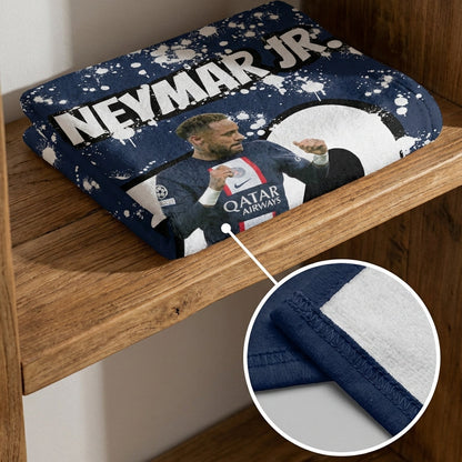 Two folded towels with a sports player design on a wooden shelf.