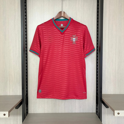 Red sports jersey with a logo on a hanger against a light wooden panel background