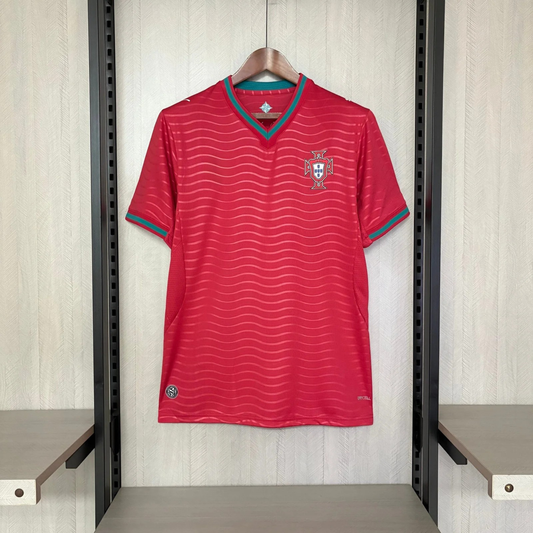 Red sports jersey with a logo on a hanger against a light wooden panel background