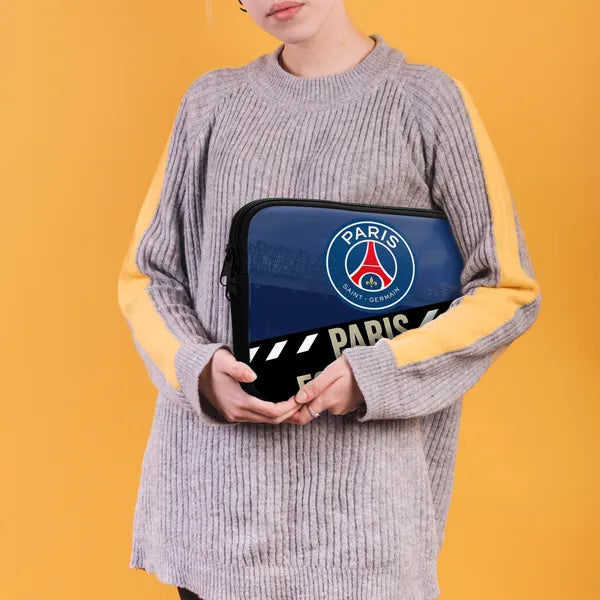Person holding a Paris Saint-Germain laptop case against a yellow background