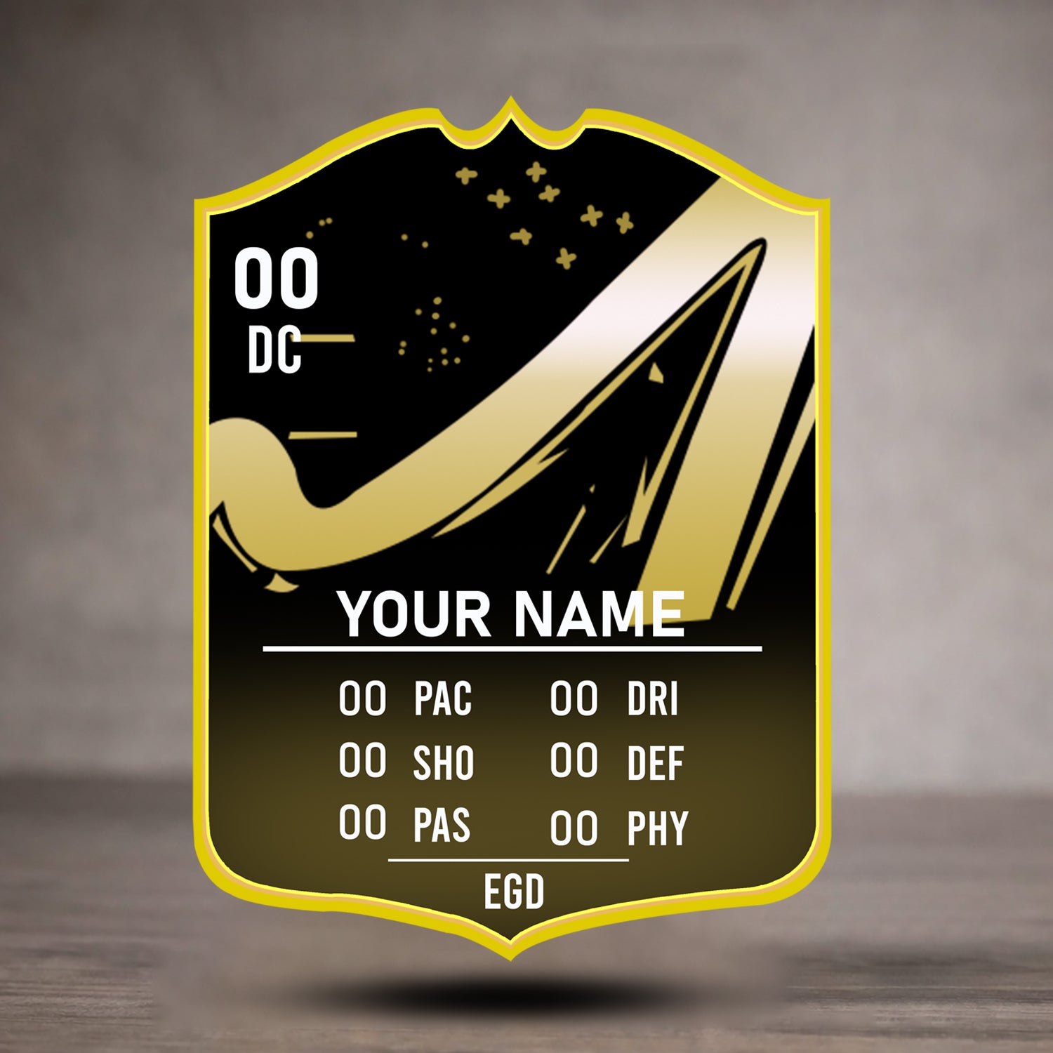 Shield-shaped emblem with gold and black design on a wooden surface