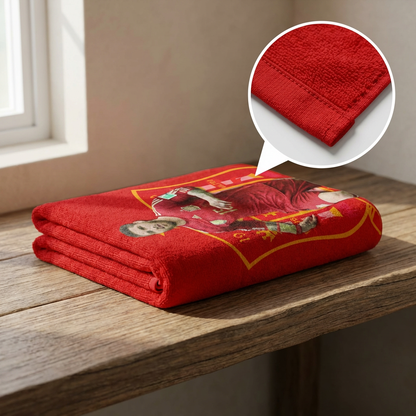 Red blanket with embroidery on a wooden surface, close-up of fabric texture.