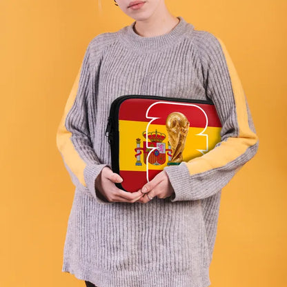 Person holding a pouch with a design of a trophy and Spanish flag on an orange background