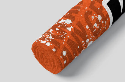 Orange towel with white pattern on a gray background