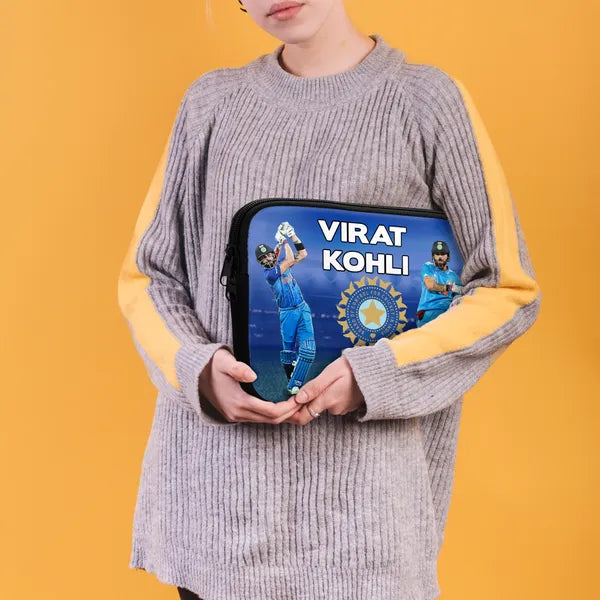 Person holding a pouch with Virat Kohli branding on an orange background
