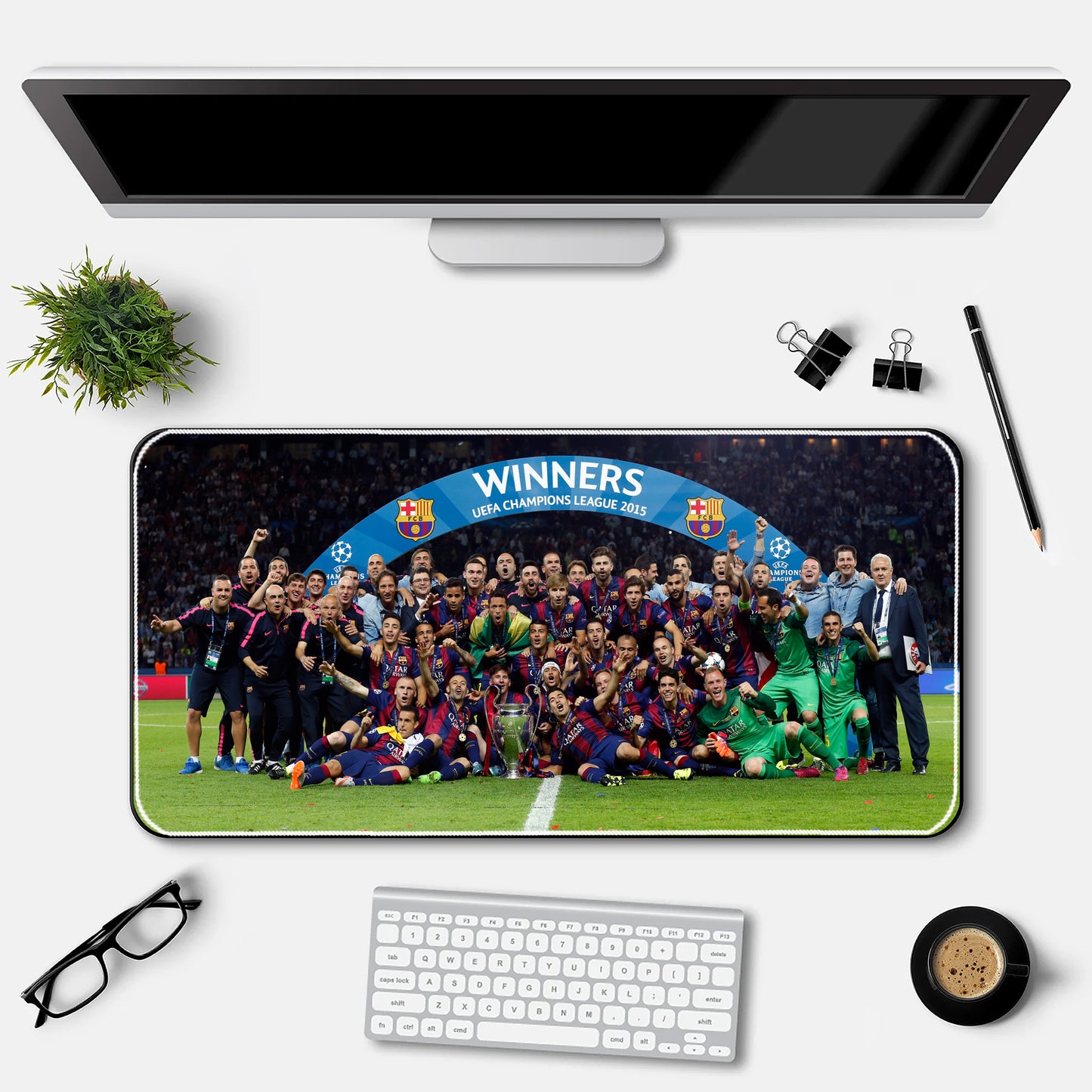 Desk setup with a large mouse pad featuring a soccer team photo and 'WINNERS' text, above a computer monitor and keyboard.