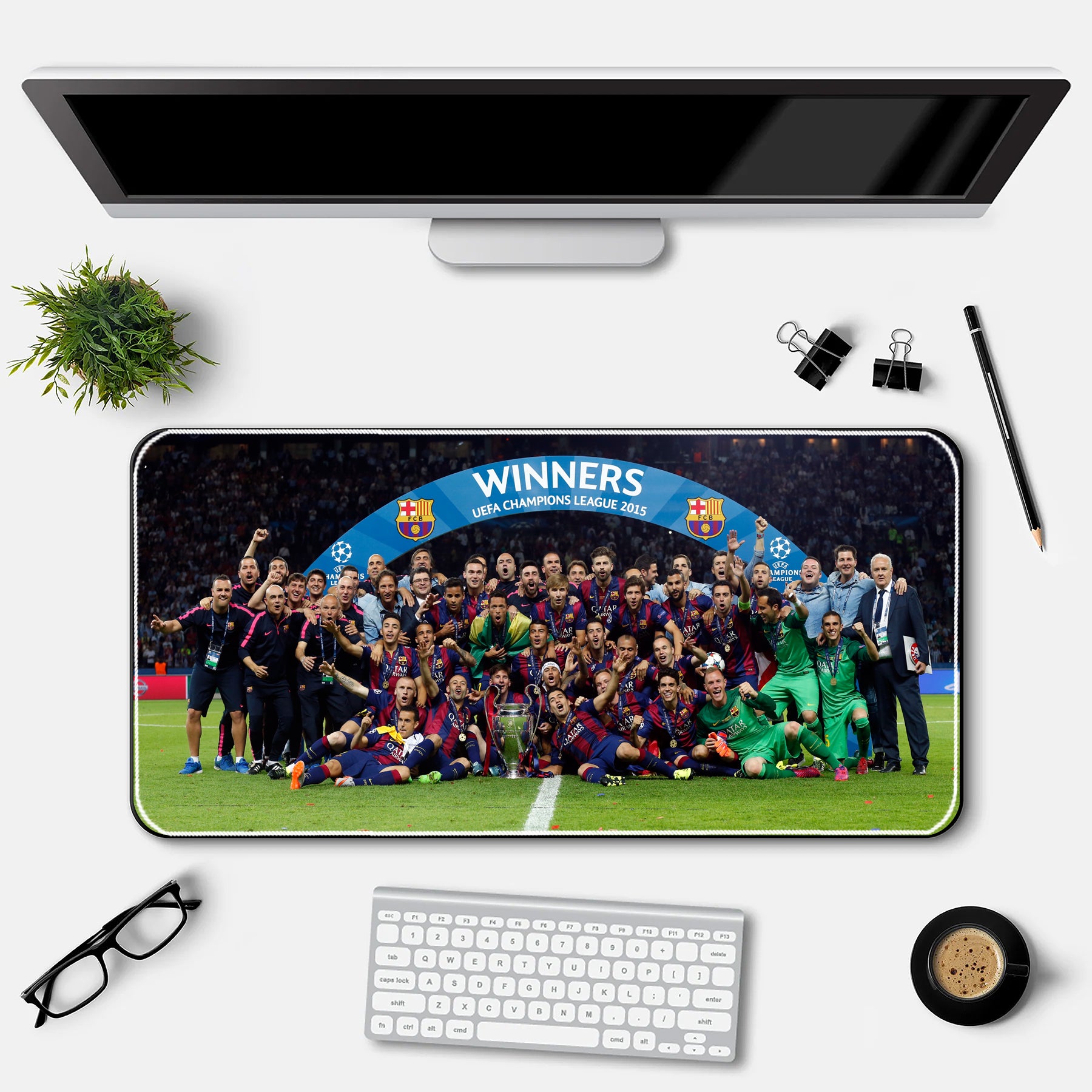 Desk setup with a large mouse pad featuring a soccer team photo and 'WINNERS' text, above a computer monitor and keyboard.