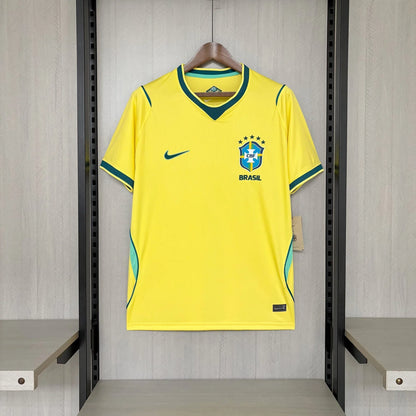 Yellow soccer jersey with Nike logo on a hanger against a gray wall.