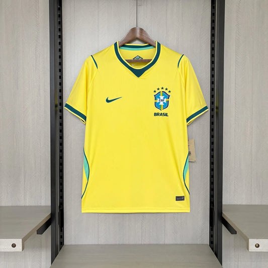 Yellow soccer jersey with Nike logo on a hanger against a gray wall.
