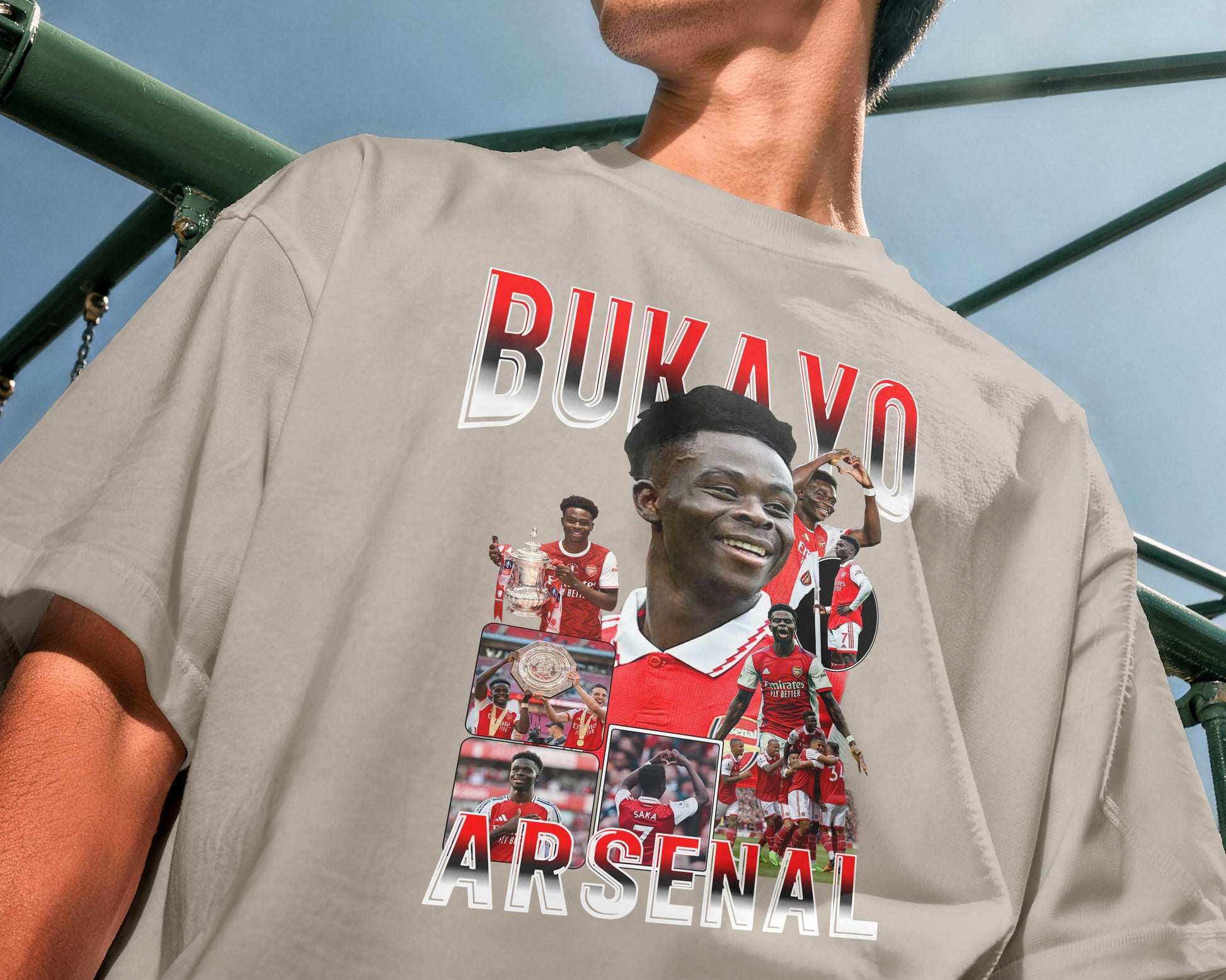 Person wearing a gray t-shirt with Arsenal football club graphics and text.